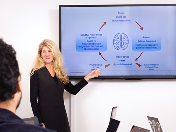 Dessa Bergen-Cico points to a screen