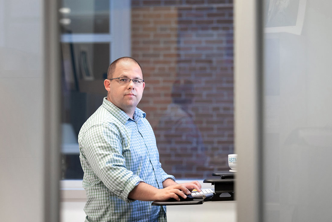 Professor David Larsen standing at his computer