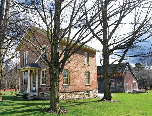 Harriet Tubman Home Brick house with a wooden barn behind it