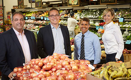 Local businessowners who contributed to a charity posing for a picture in a grocery store Local businessowners who contributed to a charity posing for a picture in a grocery store