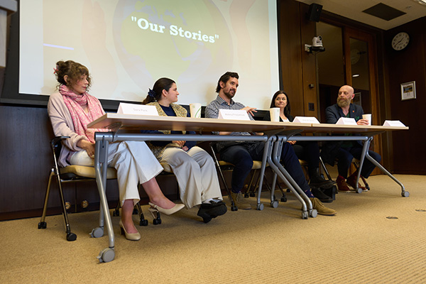 Five panelists sitting at a table during a discussion titled