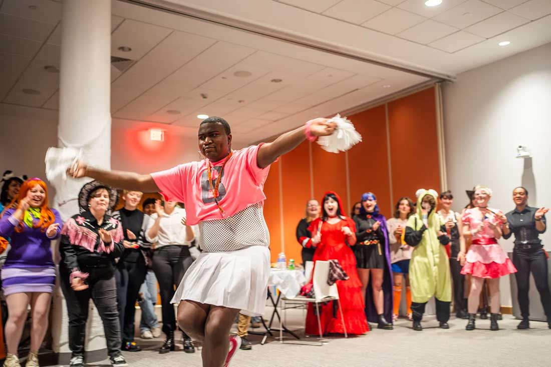 A student dances while others cheer on.