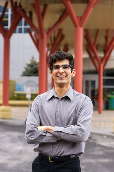 Nathan Torabi poses outside with an unknown building in the background.