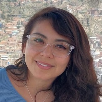 Headshot of a smiling person with dark hair and glasses.