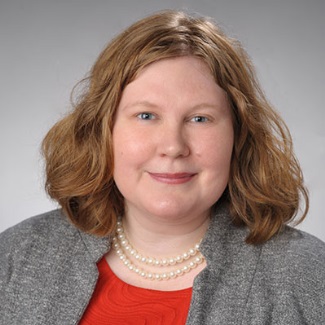 Portrait of a person with red hair wearing a red shirt and pearl necklace