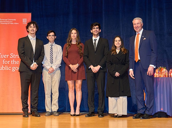 Five students stand next to Dean David Van Slyke as they receive their awards