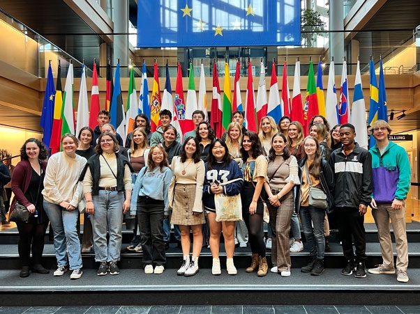 Students gather for a photo in front of European national flags