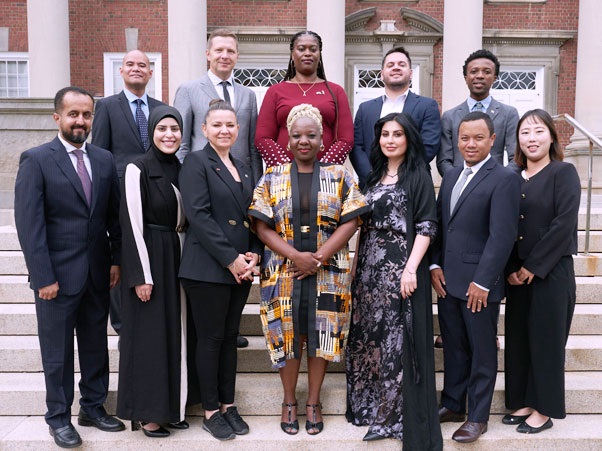 The 12 Hubert H. Humphrey fellows stand in front of Maxwell Hall